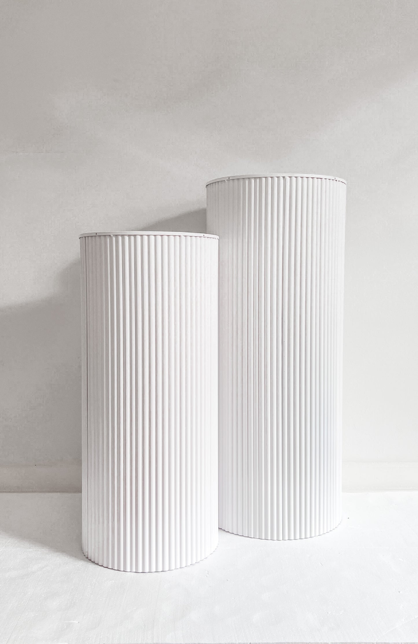 Front view two metal plinths in white