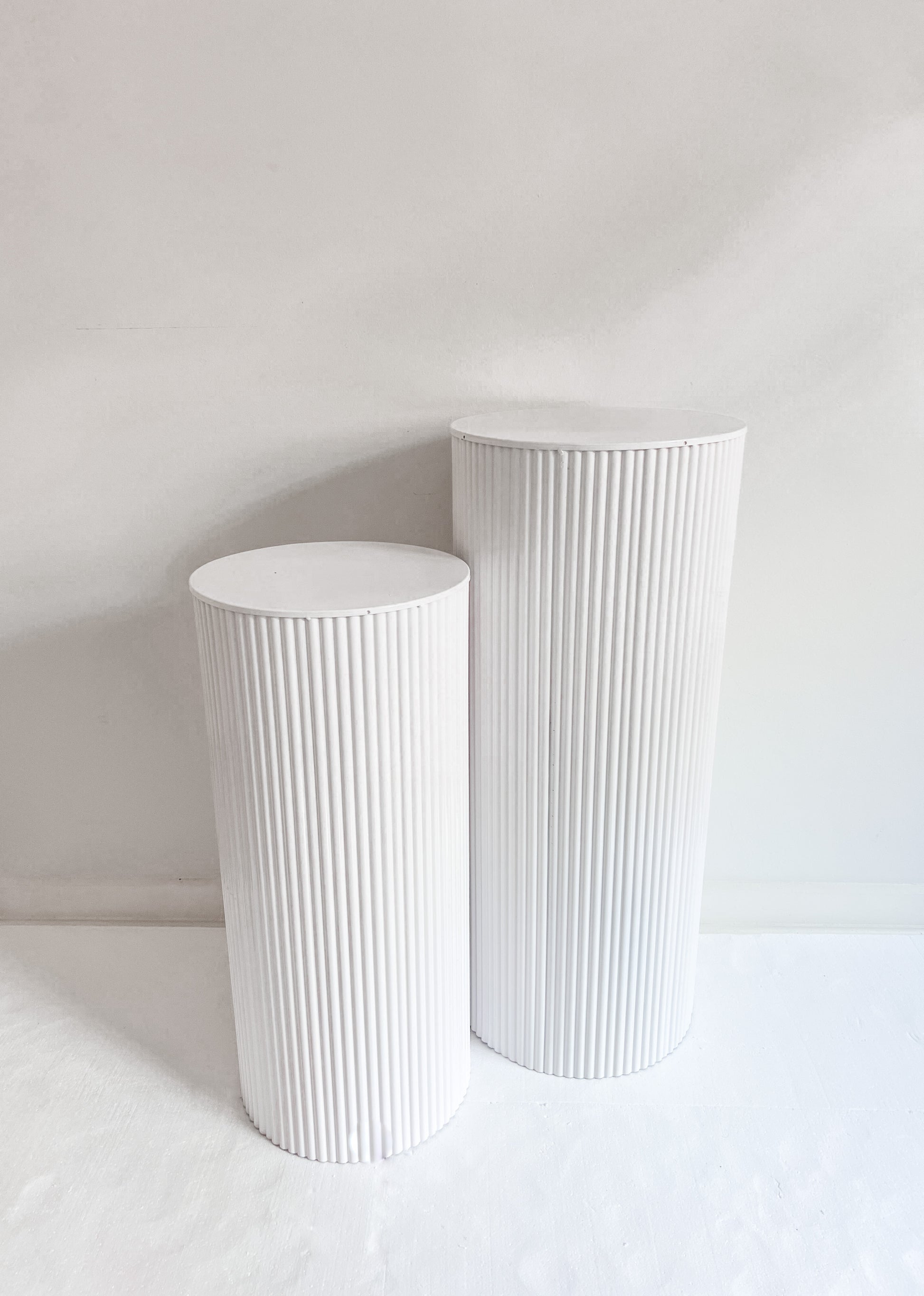 Shiny white metal plinths for hire 
