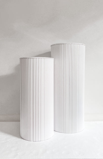 Front view two metal plinths in white 
